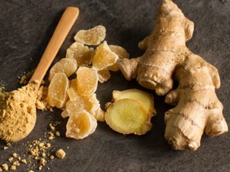 Ginger root, candied and ginger powder in wooden spoon over grey AdobeStock 248833271 U61464433025QeA 1440x752@IlSole24Ore Web