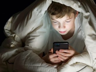 Social,Media,Addiction,Boy,Hiding,Under,The,Blanket,At,Night bambinischermo