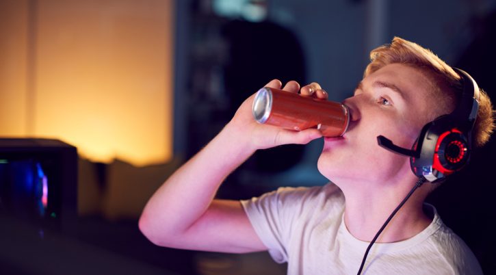 Teenage Boy Drinking Caffeine Energy Drink Gaming At Home Using Dual Computer Screens At Night energy drink adolescente ragazzo Depositphotos 326451382 S 1