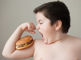 fat boy wants to eat burger that lies on biceps obesita nuova scaled