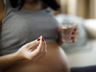 Pregnant woman taking pill at home paracetamolo in gravidanza