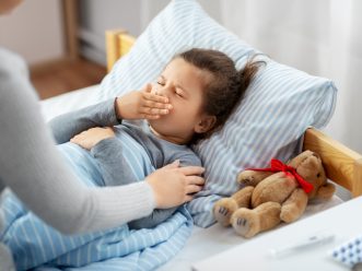 mother and sick little daughter in bed at home virus sinciziale